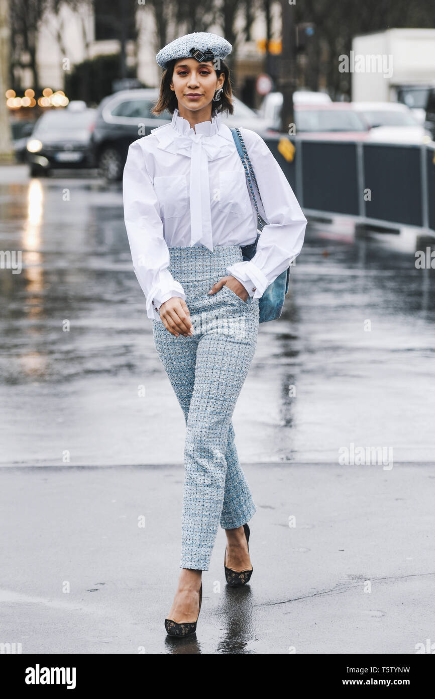 Paris, France - March 5, 2019: Street style - Woman wearing wearing a white  shirt, light blue pants, black heels, light blue hat and printed Chanel ba  Stock Photo - Alamy