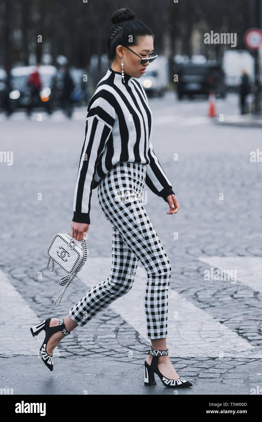 Paris, France - March 5, 2019: Street style - Woman wearing black white  striped jumper, plaid pants and Chanel bag, before a fashion show during  Pari Stock Photo - Alamy