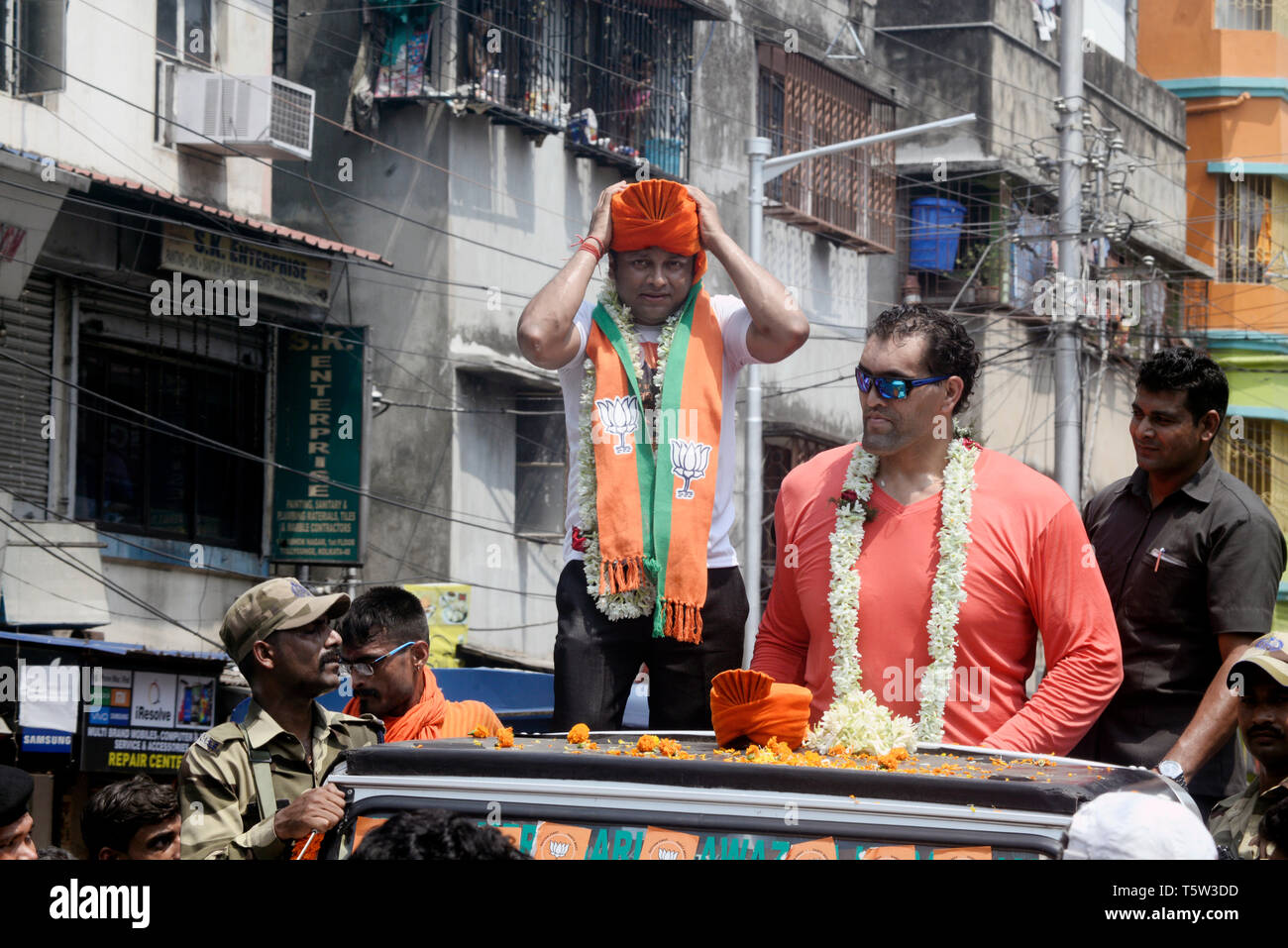 Kolkata, India. 26th Apr, 2019. WWE superstar wrestler The Great Khali (right) campaigns for Bharatiya Janta Party or BJP candidate for Jadavpur constituency Anupam Hazra (left) during the nomination filling procession for Lok Sabha election 2019. Credit: Saikat Paul/Pacific Press/Alamy Live News Stock Photo