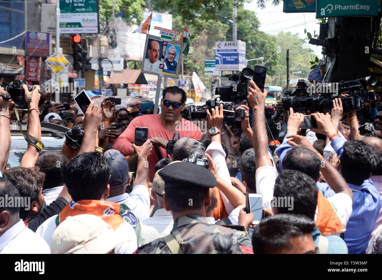 Kolkata, India. 26th Apr, 2019. WWE superstar wrestler The Great Khali (in middle) campaigns for Bharatiya Janta Party or BJP candidate for Jadavpur constituency Anupam Hazra during the nomination filling procession for Lok Sabha election 2019. Credit: Saikat Paul/Pacific Press/Alamy Live News Stock Photo