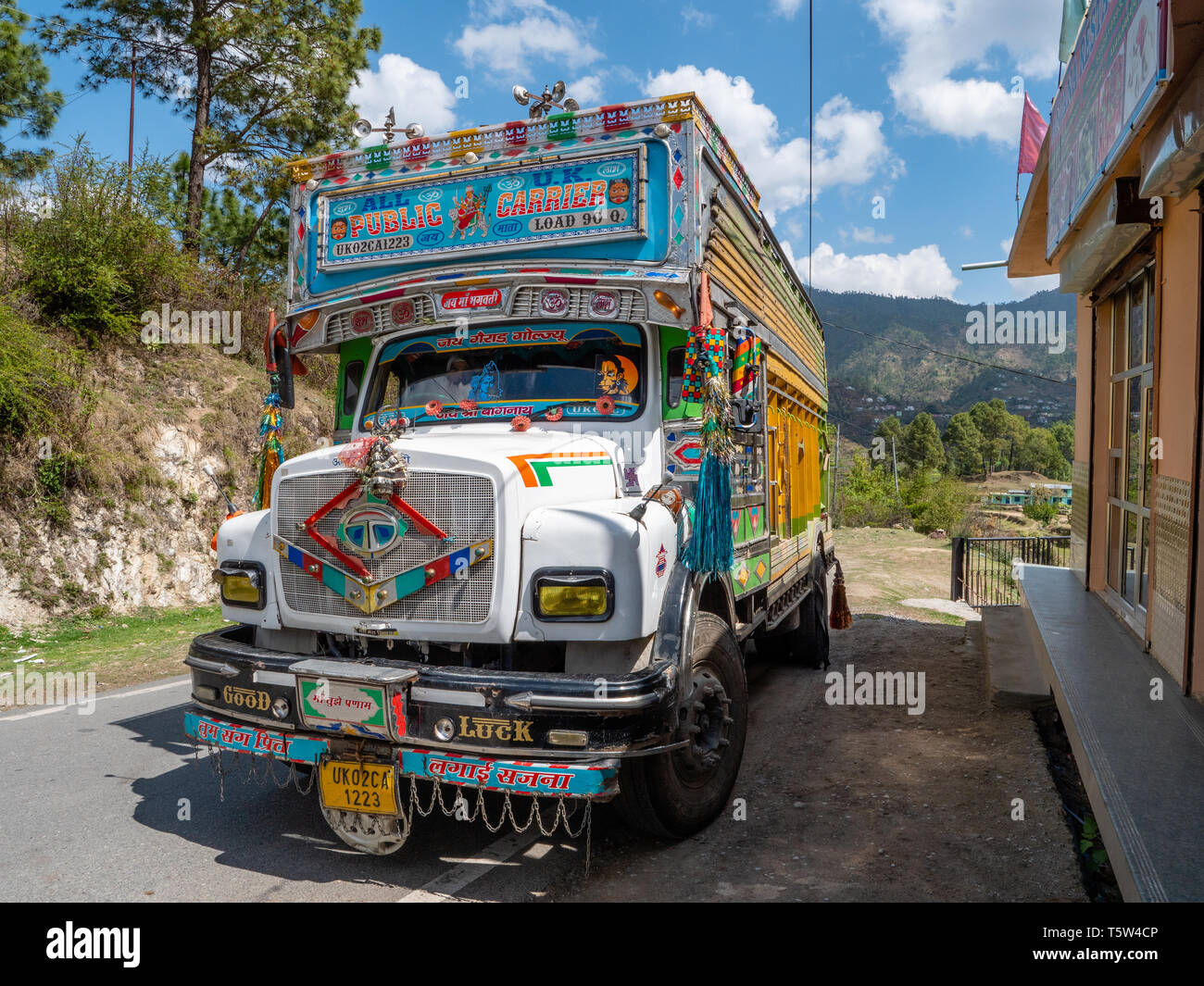 Colourfully painted and elaborately decorated heavy goods lorry on a road through the Binsar region of Uttarakhand Northern India Stock Photo