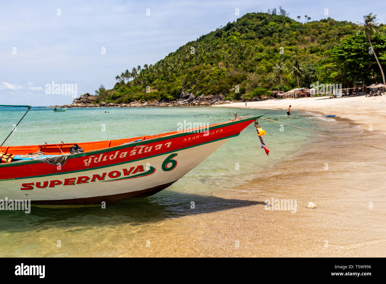 Koh Phangan, Thailand - April 24, 2019: Boat in the crystal clear waters of Bottle Beach on Koh Phangan island Stock Photo