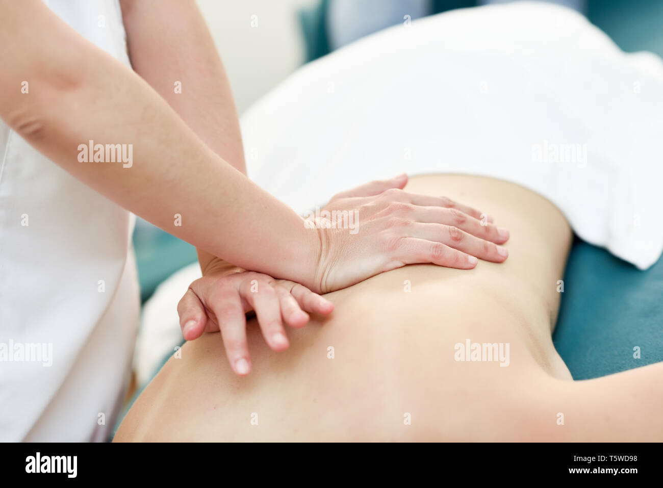 Young woman receiving a back massage by professional therapist. Stock Photo
