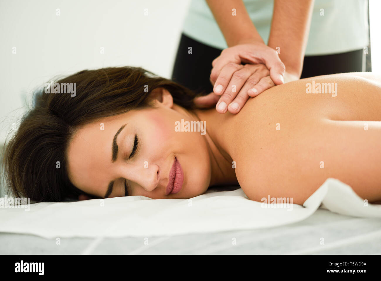 Young woman receiving a back massage in a spa center. Stock Photo