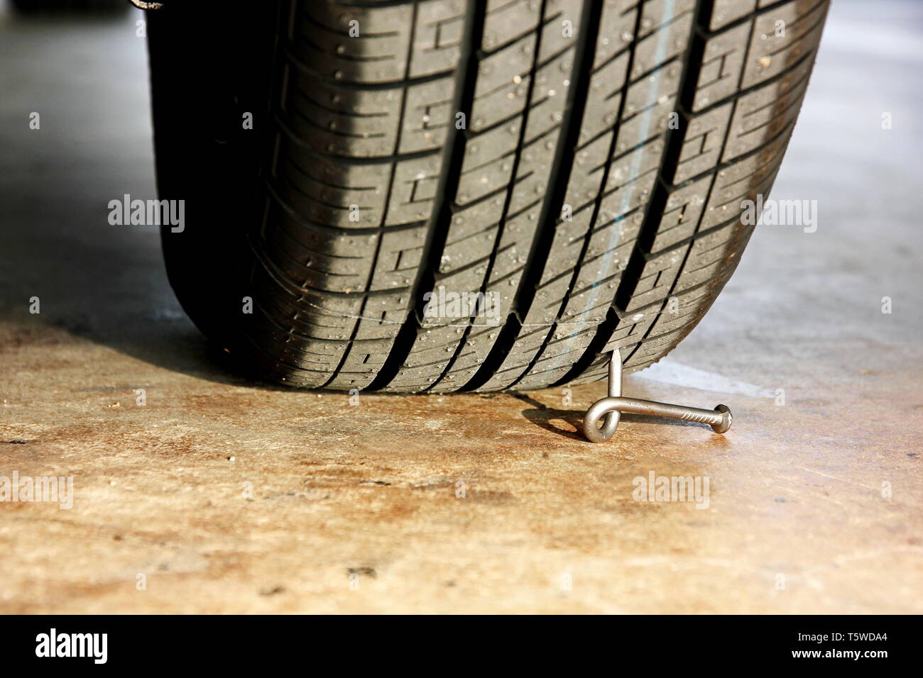twist nail under car wheel Stock Photo Alamy