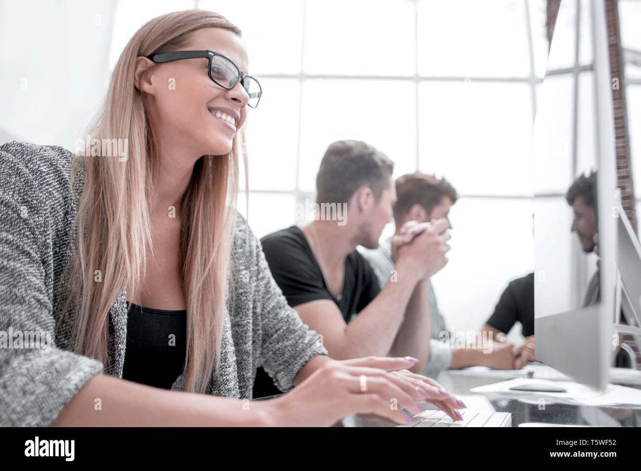 young colleagues working in the office using computers Stock Photo