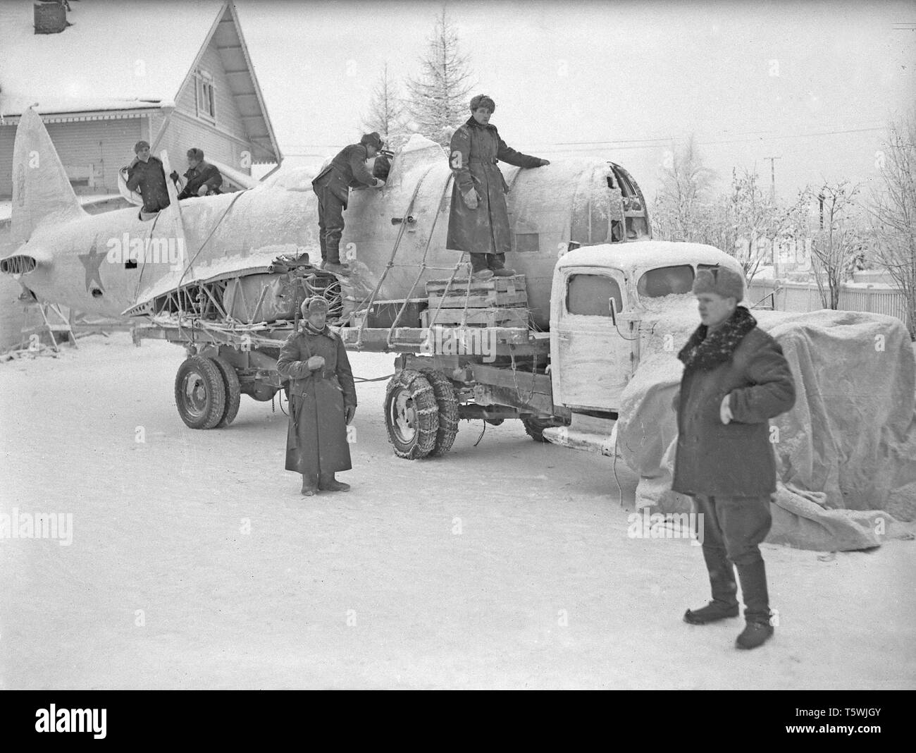 The Winter War. A military conflict between the Soviet union and Finland. It began with a Soviet invasion on november 1939 when Soviet infantery crossed the border on the Karelian Isthmus. About 9500 Swedish volunteer soldiers participated in the war. Here at Rovaniemi, North Finland. The unit called Lapland Group successfully stopped the Soviet troups,  though outnumbered, at Salla and Petsamo. Picture shows Finnish soldiers loading part of a Soviet aircraft that was shot down. January 1940. Photo Kristoffersson ref 99-3 Stock Photo
