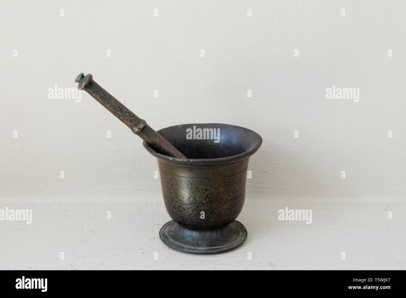 Vintage mortar and pestle. Antique brass kitchenware tool. Stock Photo