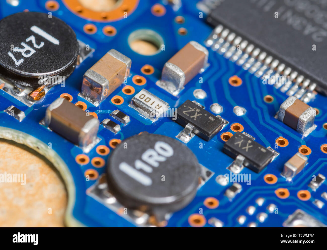 Macro closeup image of various SMT (Surface Mount Technology) components mounted on an electronics PCB (Printed Circuit Board). Stock Photo