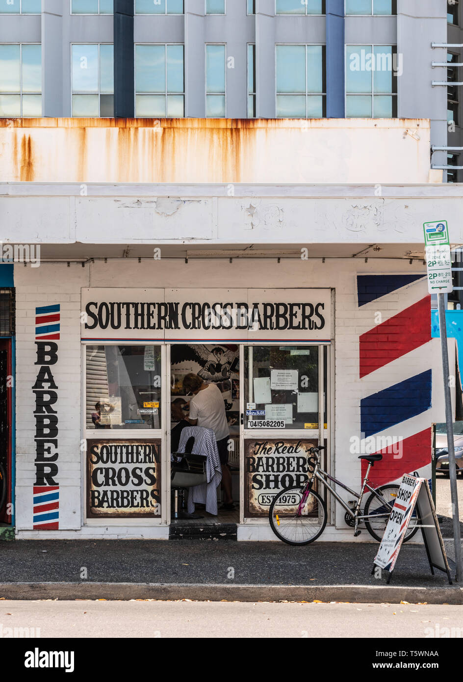 Darwin Australia - 22, 2019: Small iconic Cross Barbers shop in Bennett Street downtown, shows classic white and red colors. Barber Stock Alamy