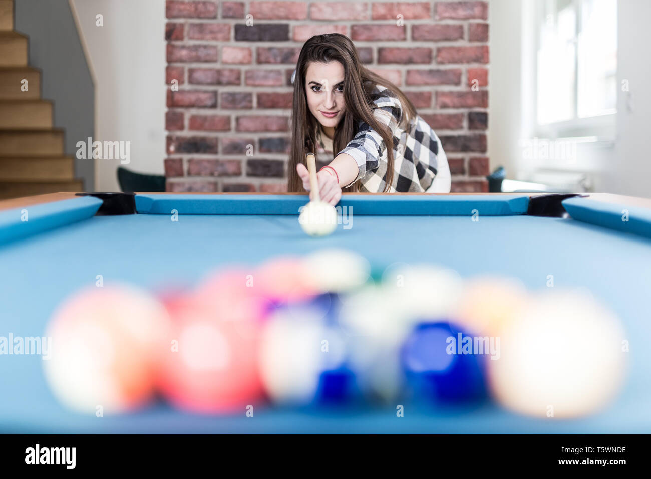 Portrait of young female playing billiards. Stock Photo