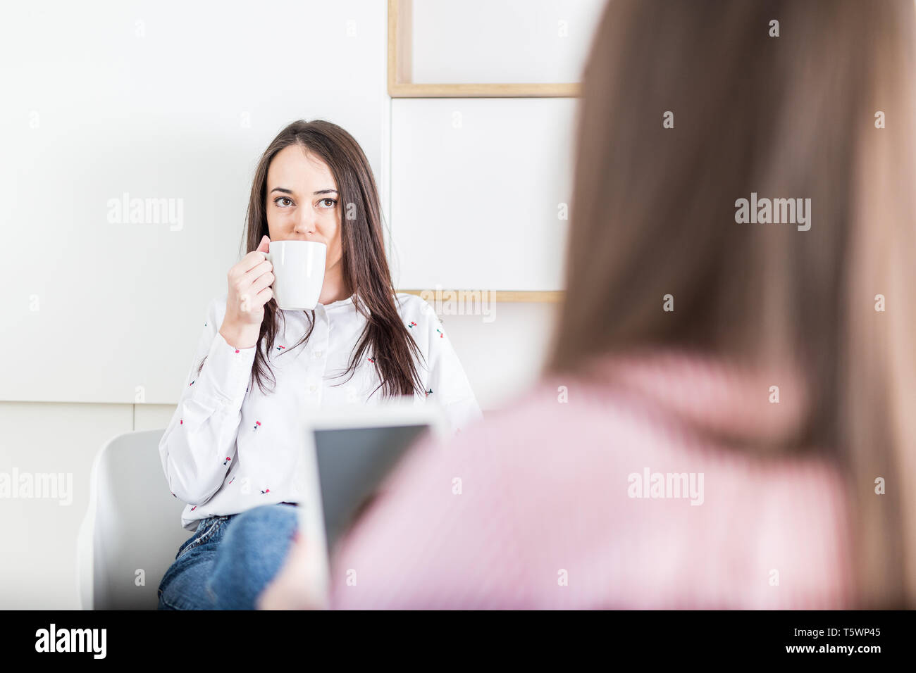 Two young businesswomen on a meeting at the office Stock Photo - Alamy