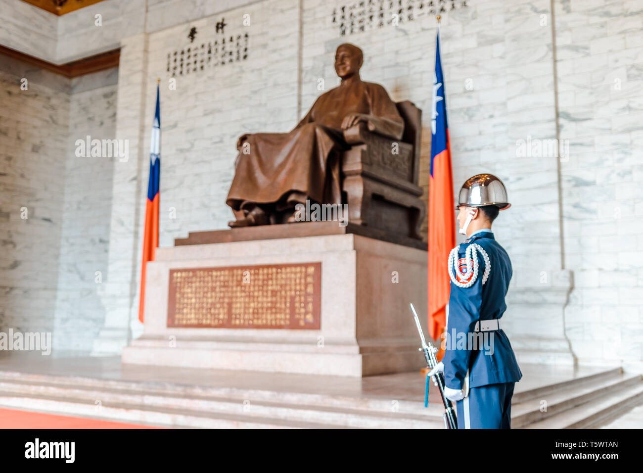 The Honor Guard of R.O.C (Soldier) performing guard duties at Chiang Kai-Shek Memorial Hall waith Chiang Kai-Shek Bronze Statue in the Background Stock Photo