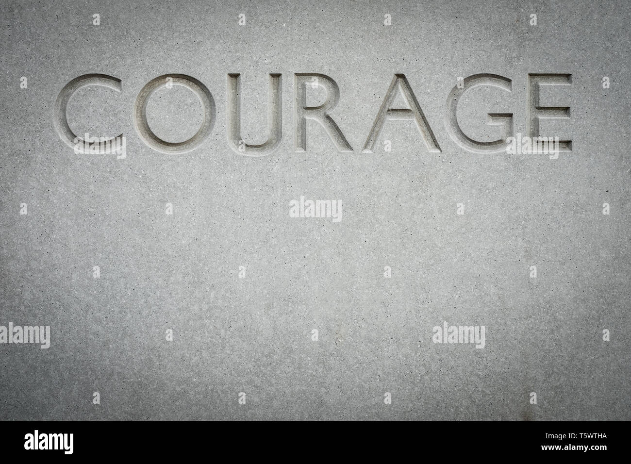 Conceptual Image Of The Word Courage Engraved Into Rock With Copy Space Stock Photo