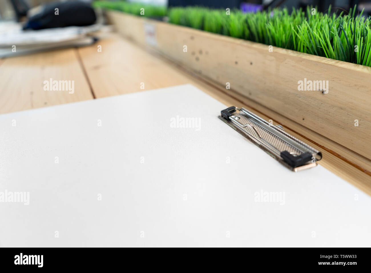 white empty plastic clipboard lay on the wood table. Stock Photo