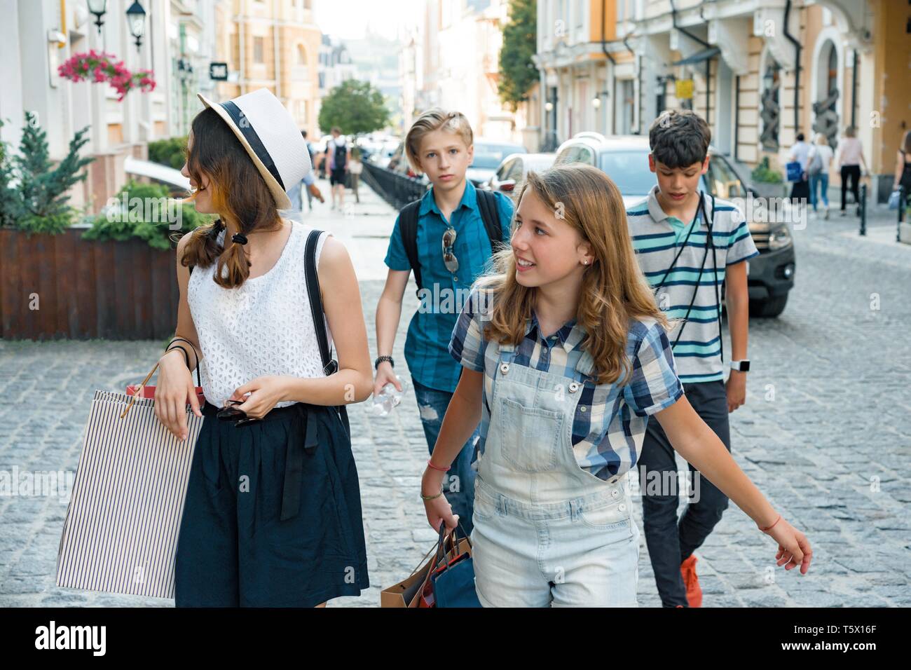Group of teenagers with shopping bags on city street Stock Photo