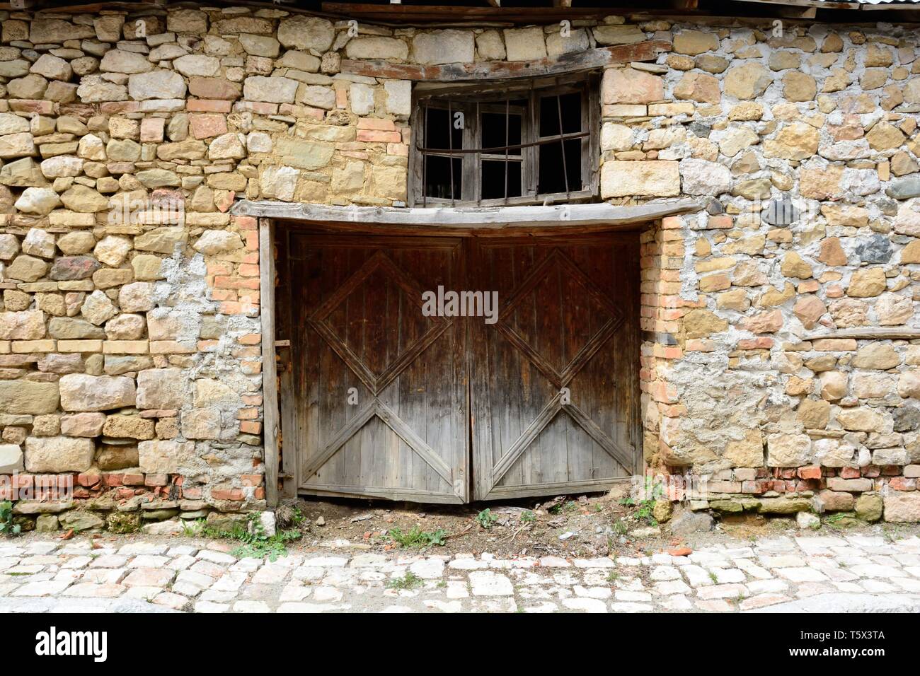 Ancient traditional Albanian stone building with with wooden door and window Voskopoja Albania