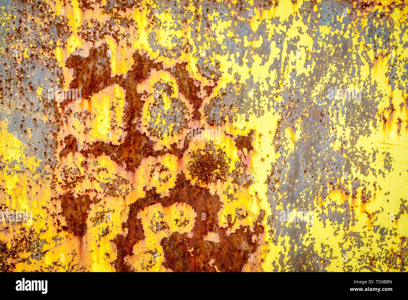 Close-up image of rusted metal surface with remnants of yellow paint Stock Photo