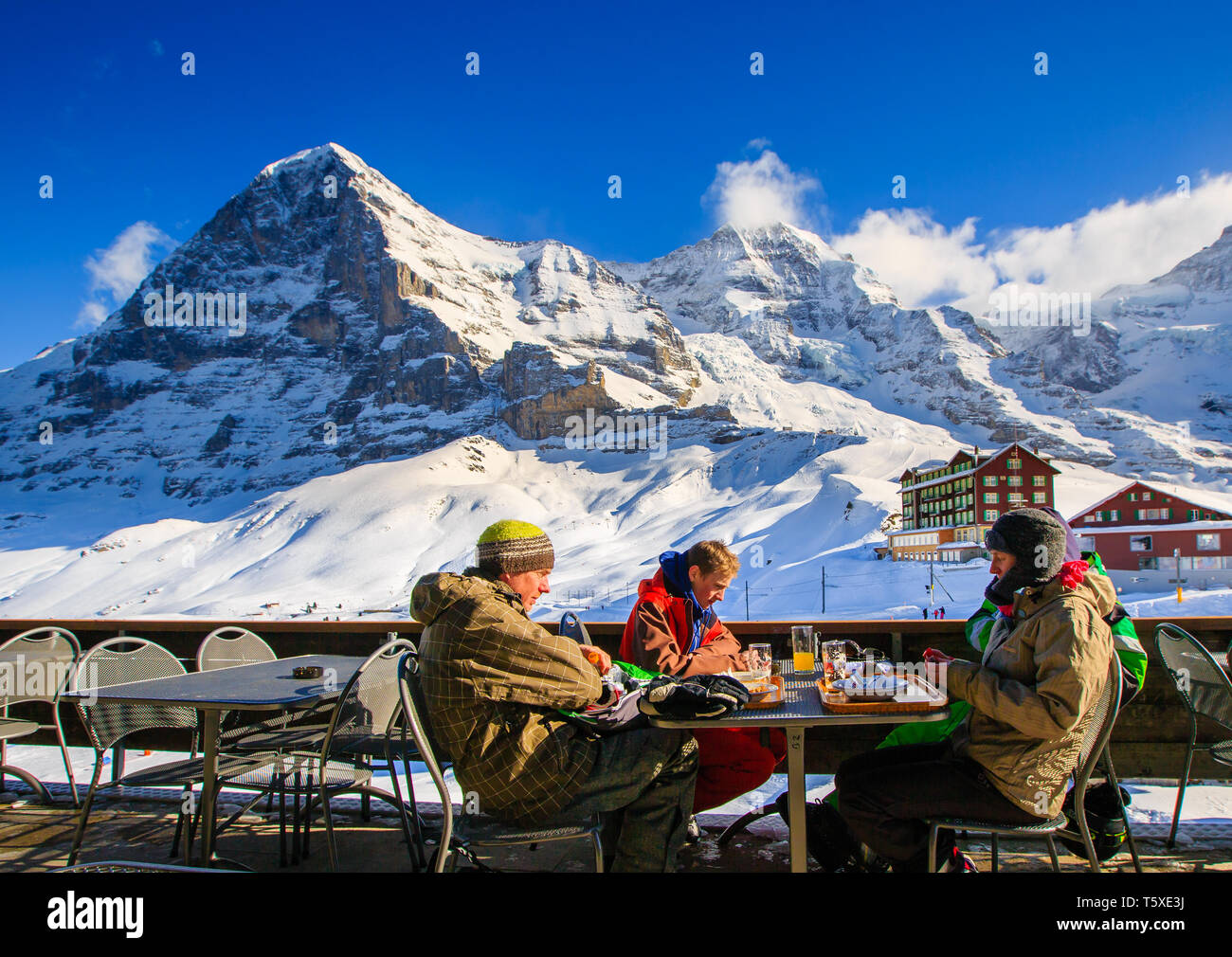 People sitting outside restaurant / bar, with Eiger north face behind, in  winter. Kleine Scheidegg, Bernese Oberland, Switzerland (Suisse Stock Photo  - Alamy