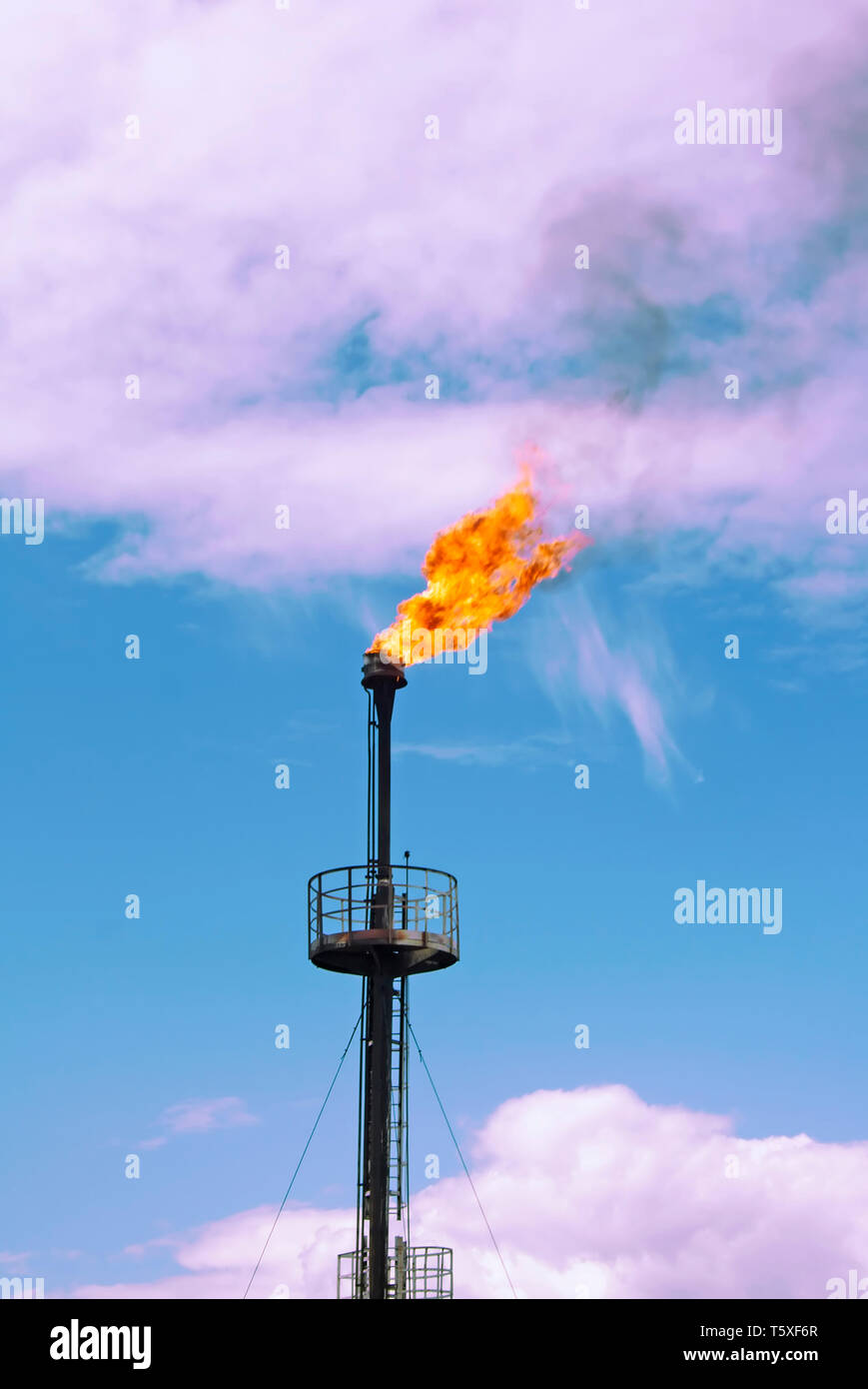 Gas flame torch. Work of gas station. Ecology and pollution. Colorful clouds Stock Photo Alamy