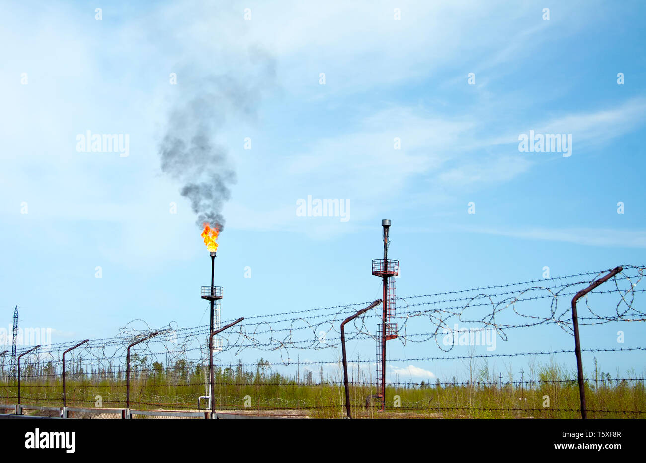 Oil reservoir and flame torch. Oil refinery plant. Gas station Stock Photo