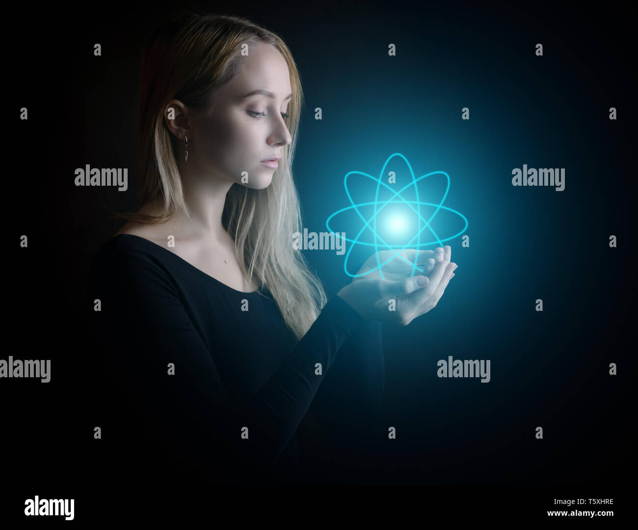 Young woman with glowing atom model - science concept. Stock Photo