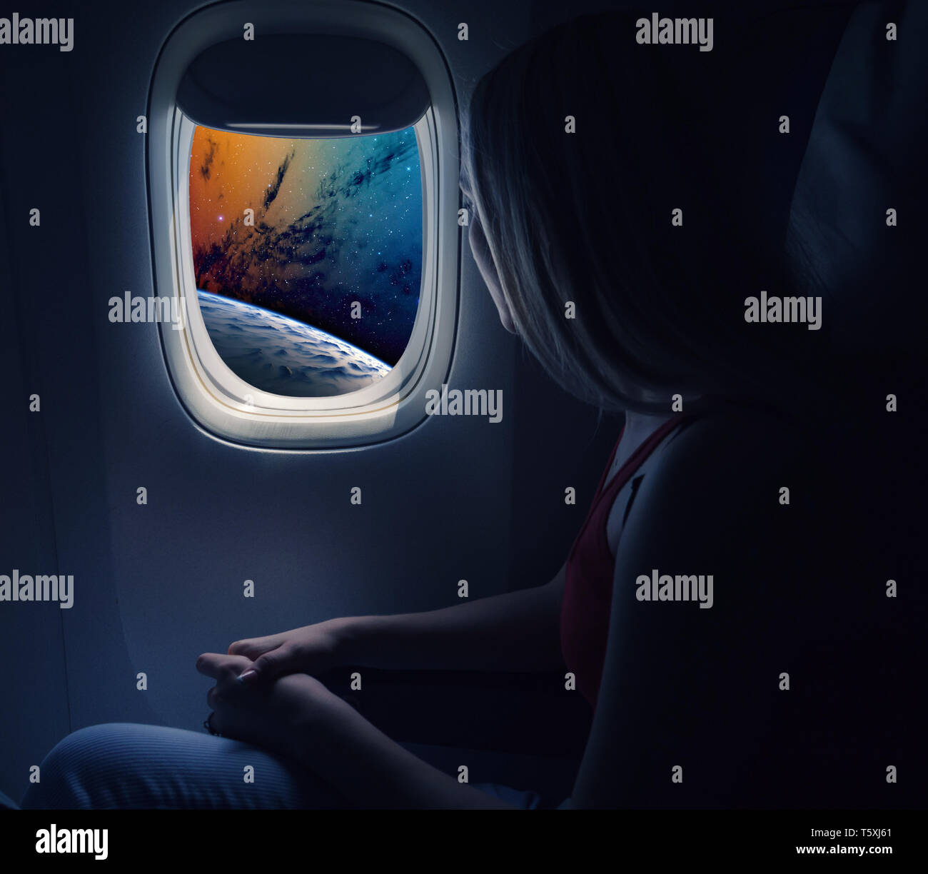 Woman in spaceship looks out the porthole. Commercial space travel concept. Stock Photo