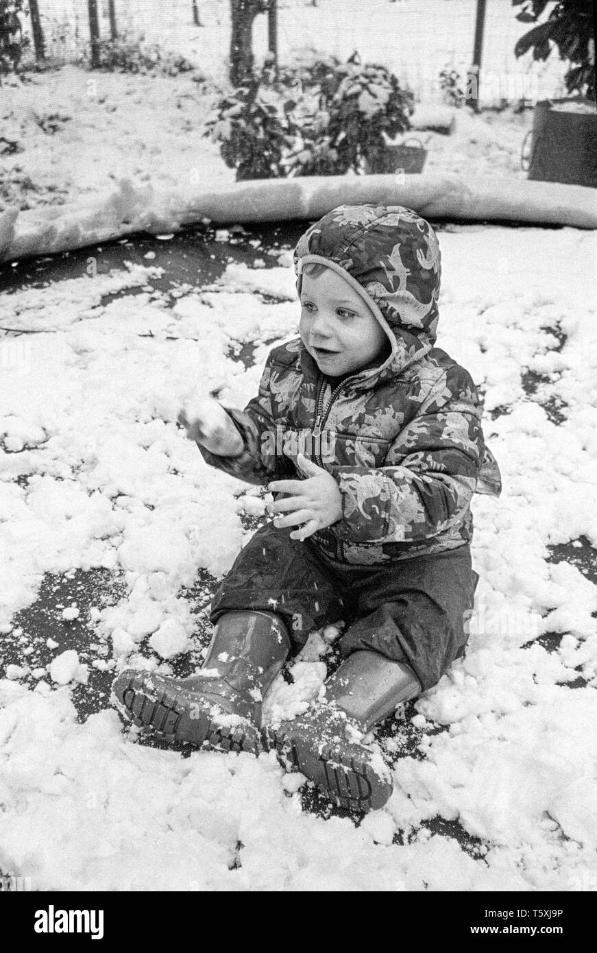 Two year old baby boy in the snow, Medstead, Hampshire, England, United Kingdom. Stock Photo