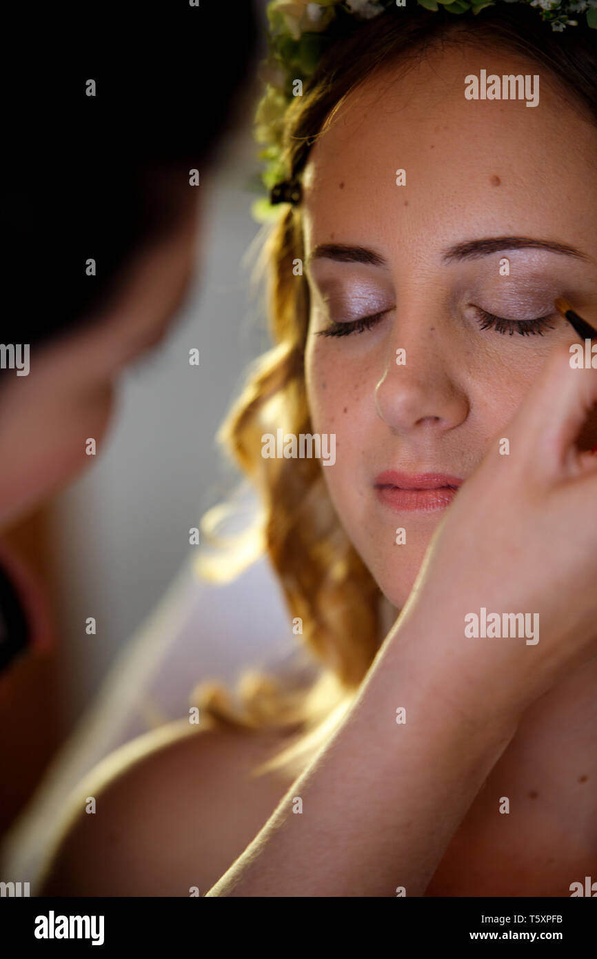 Young lovely bride smiling with flowers in her hair at the beauty salon makeup before wedding Stock Photo