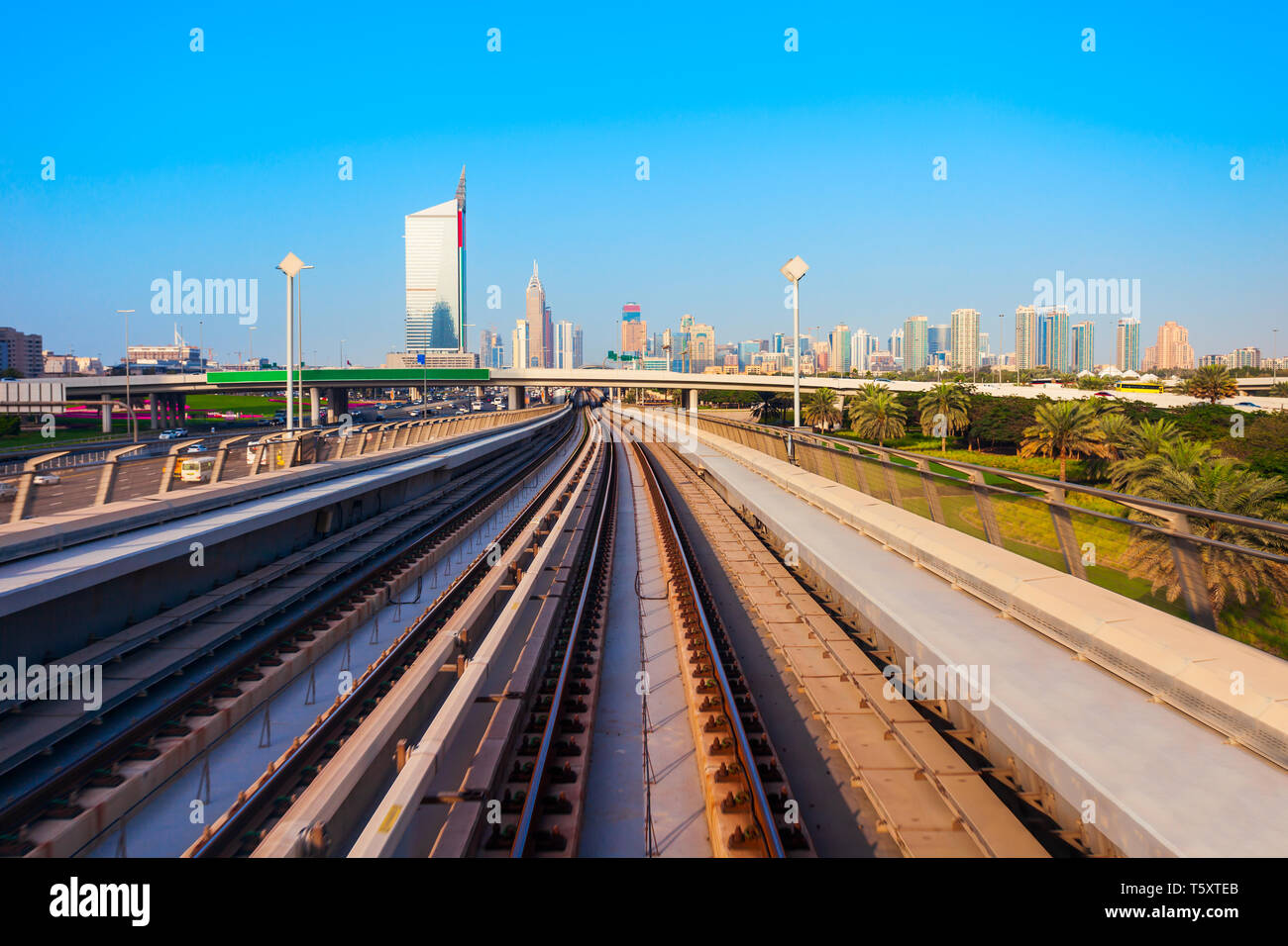 Dubai Metro train and Dubai city skyline in UAE Stock Photo