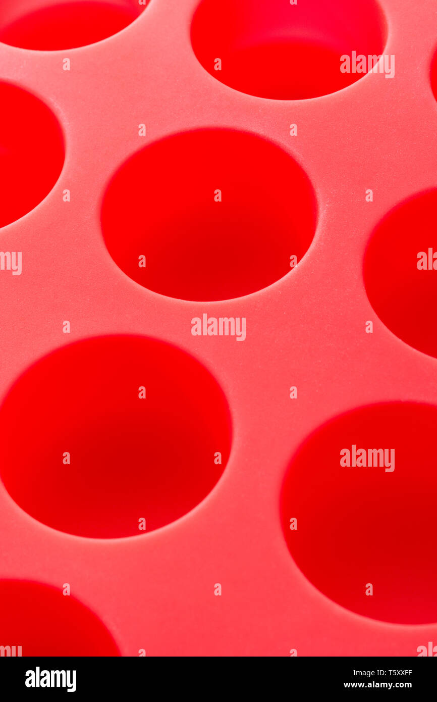 Abstract red silicone chocolate mould. Metaphor kitchen utensils