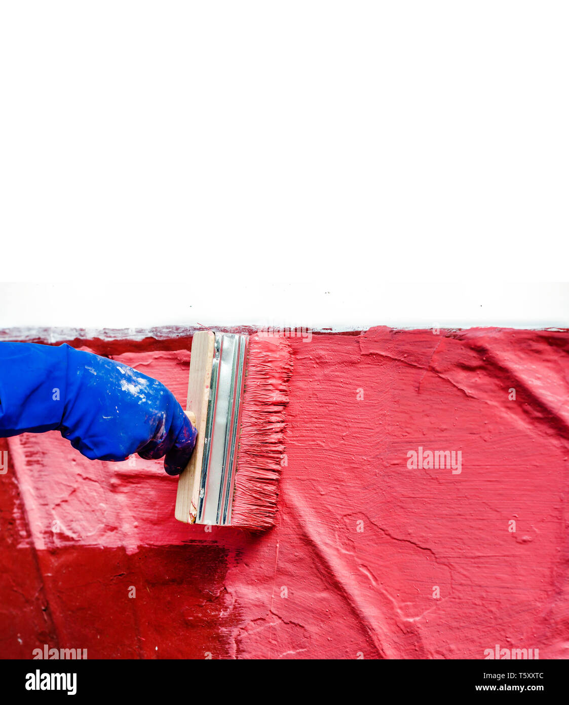Paint the wall in red with a large wide paint brush Stock Photo Alamy