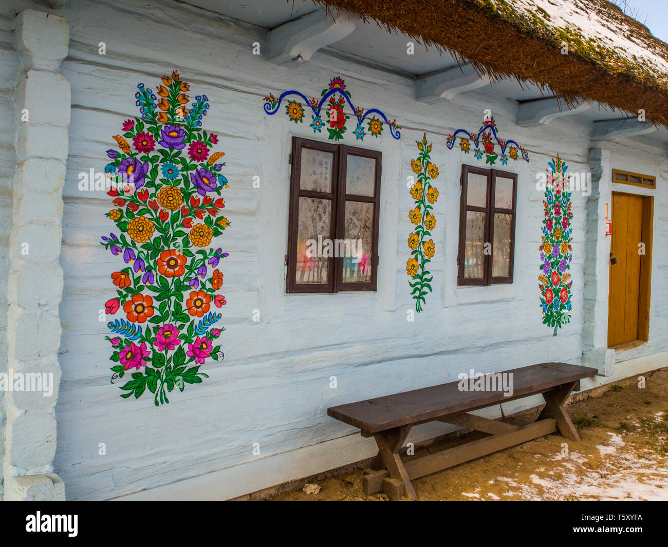 Zalipie, Poland - January  06, 2017: Colorful flowers painted on walls of wooden log house in the small village Zalipie. Poland. Easter Europe. Stock Photo