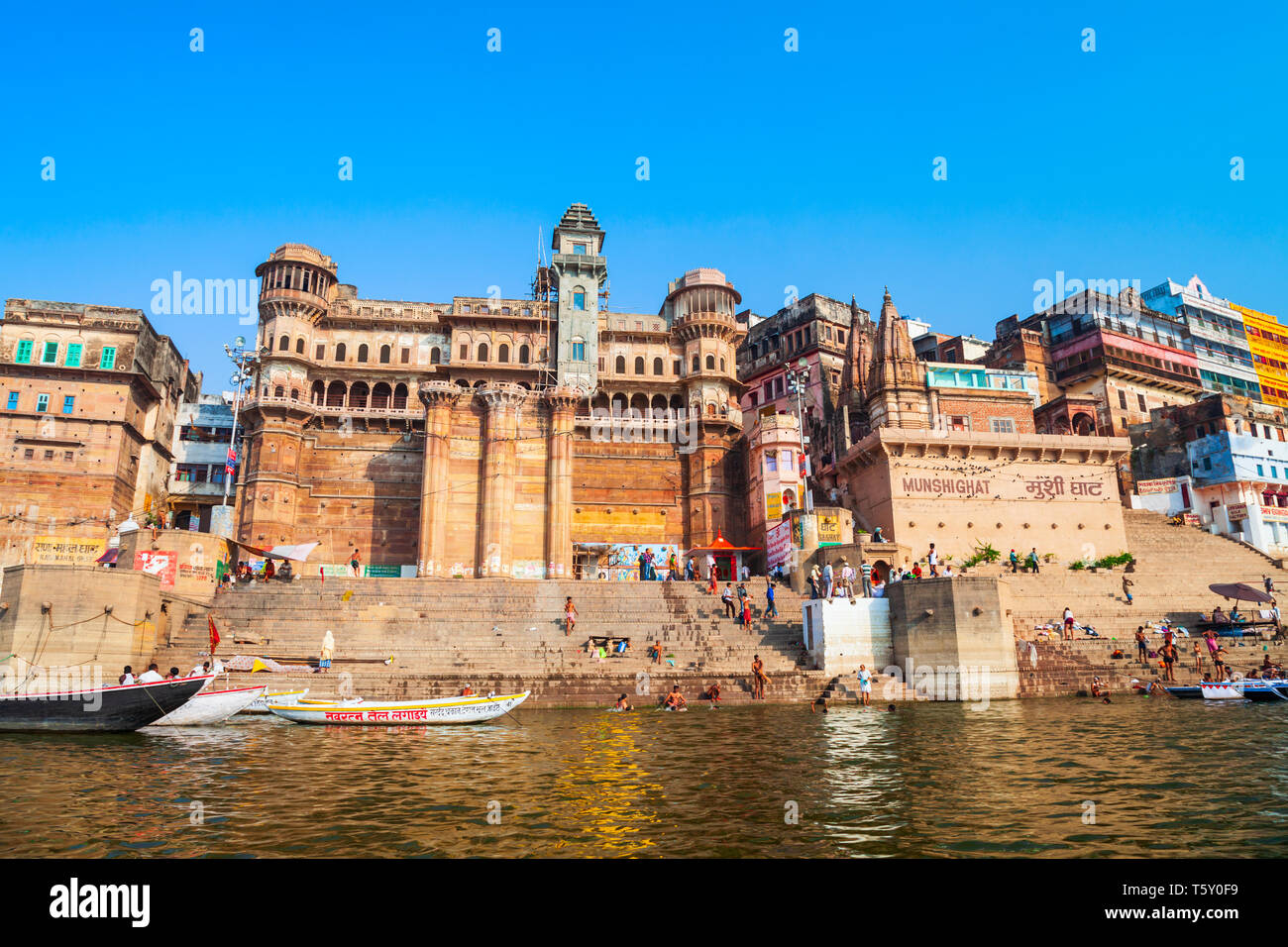 VARANASI, INDIA - APRIL 12, 2012: Colorful boats and Ganges river bank in Varanasi city in India Stock Photo