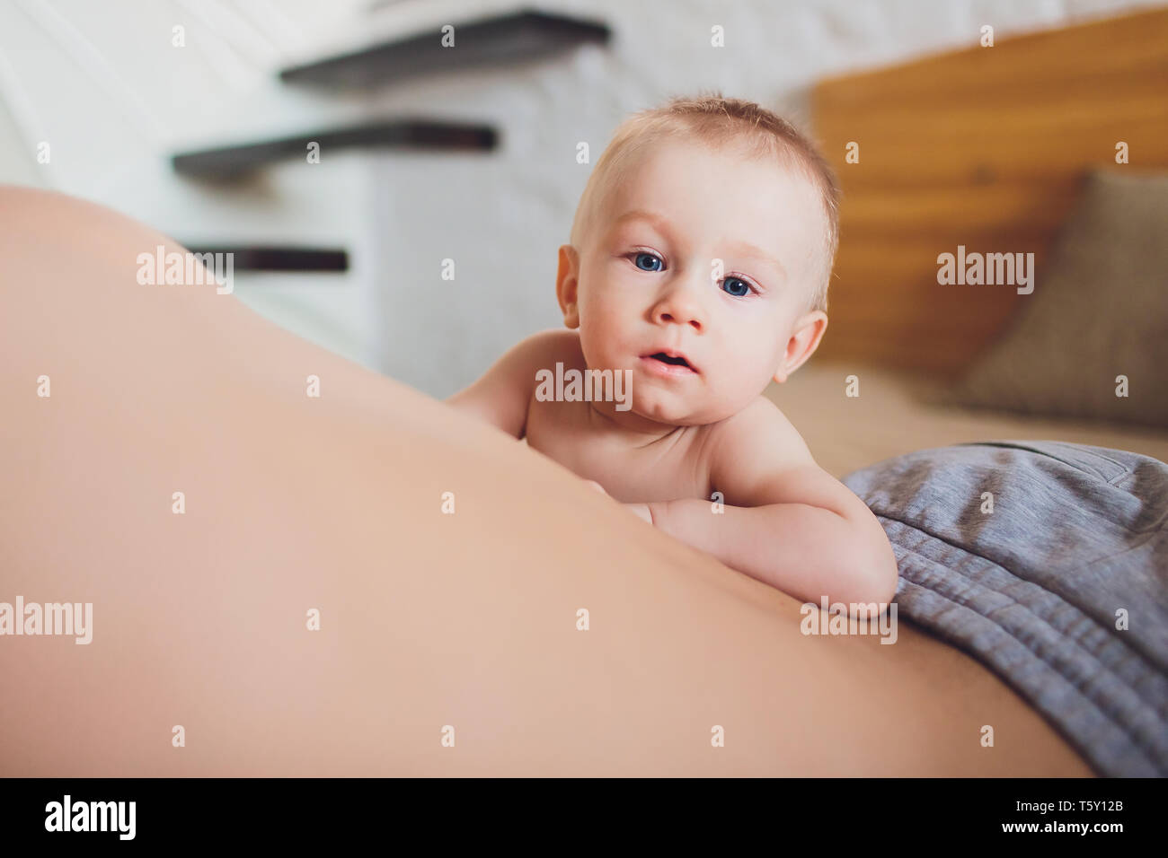 Happy father with baby lying on bed at home. Stock Photo