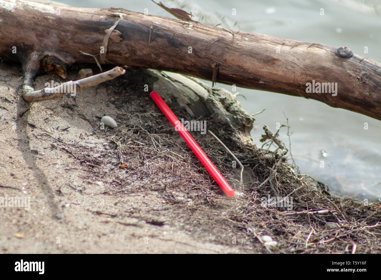 Pollution of plastic straws and fork left on beach background with