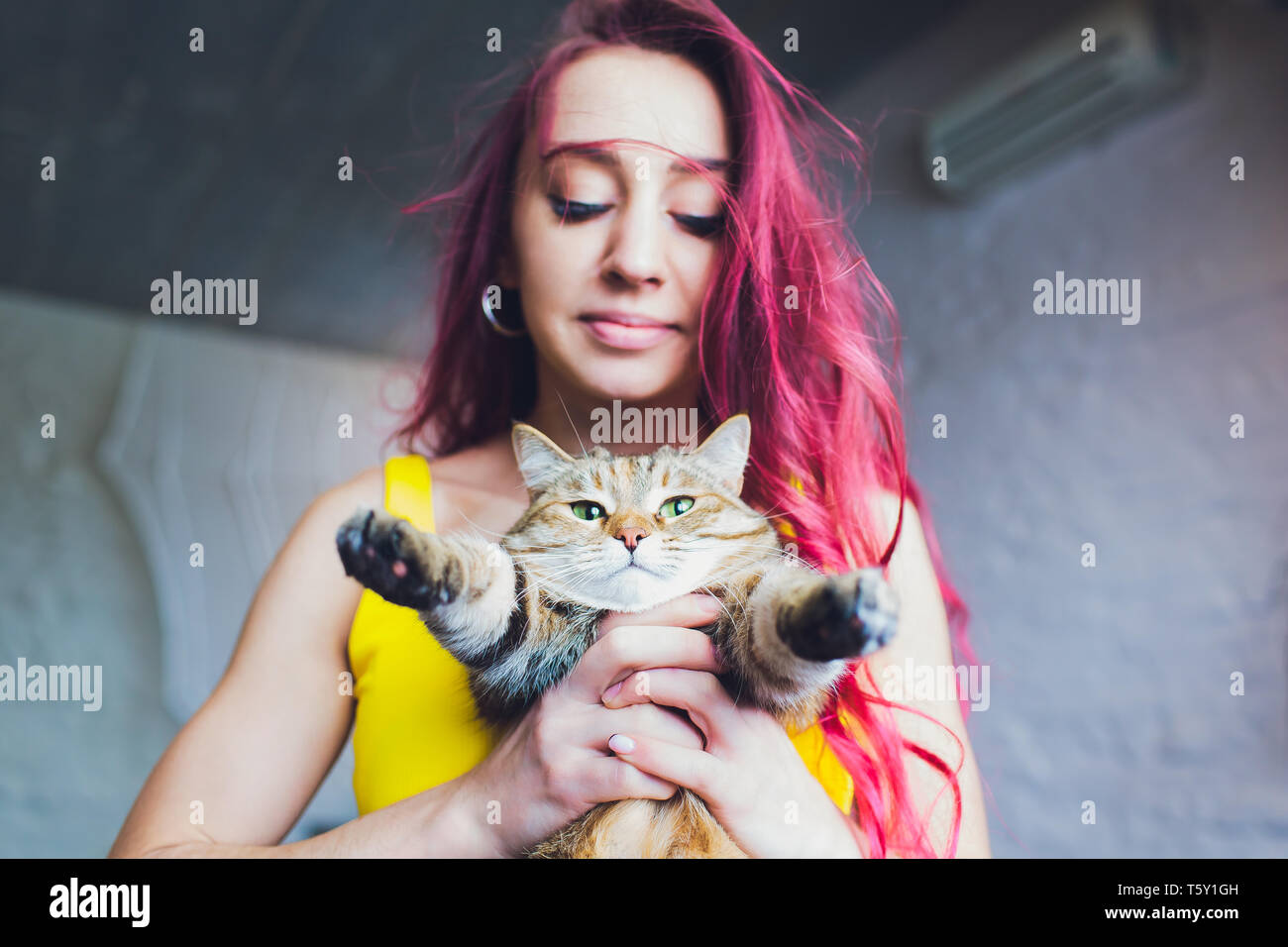 Beautiful young woman with cute cat resting at home. Stock Photo