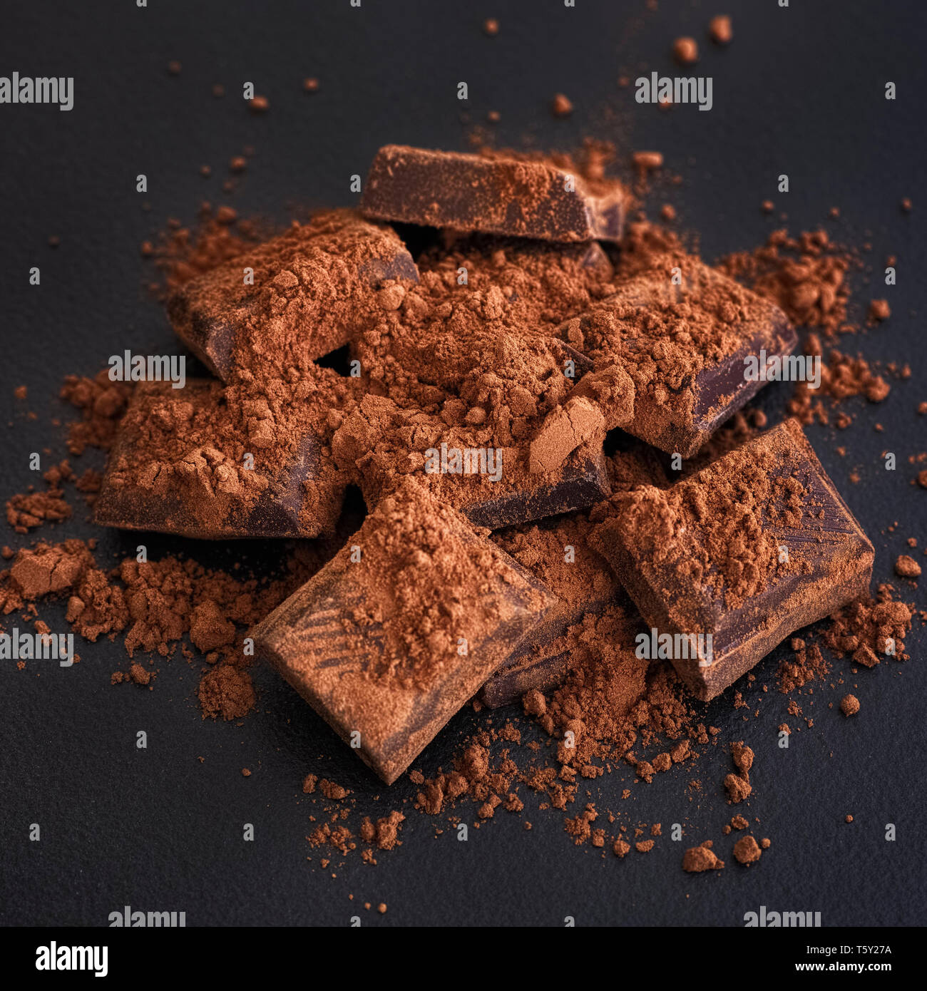 Broken dark chocolate with cocoa powder. Low key Stock Photo Alamy