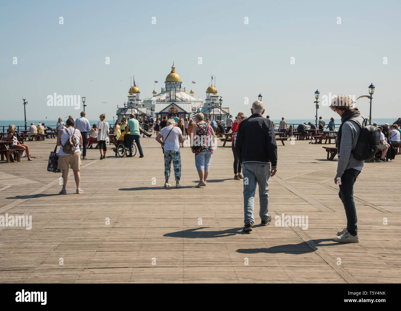 People enjoying a walk along the Eastbourne pier on a warm sunny holiday along the east Sussex coast  England UK Stock Photo
