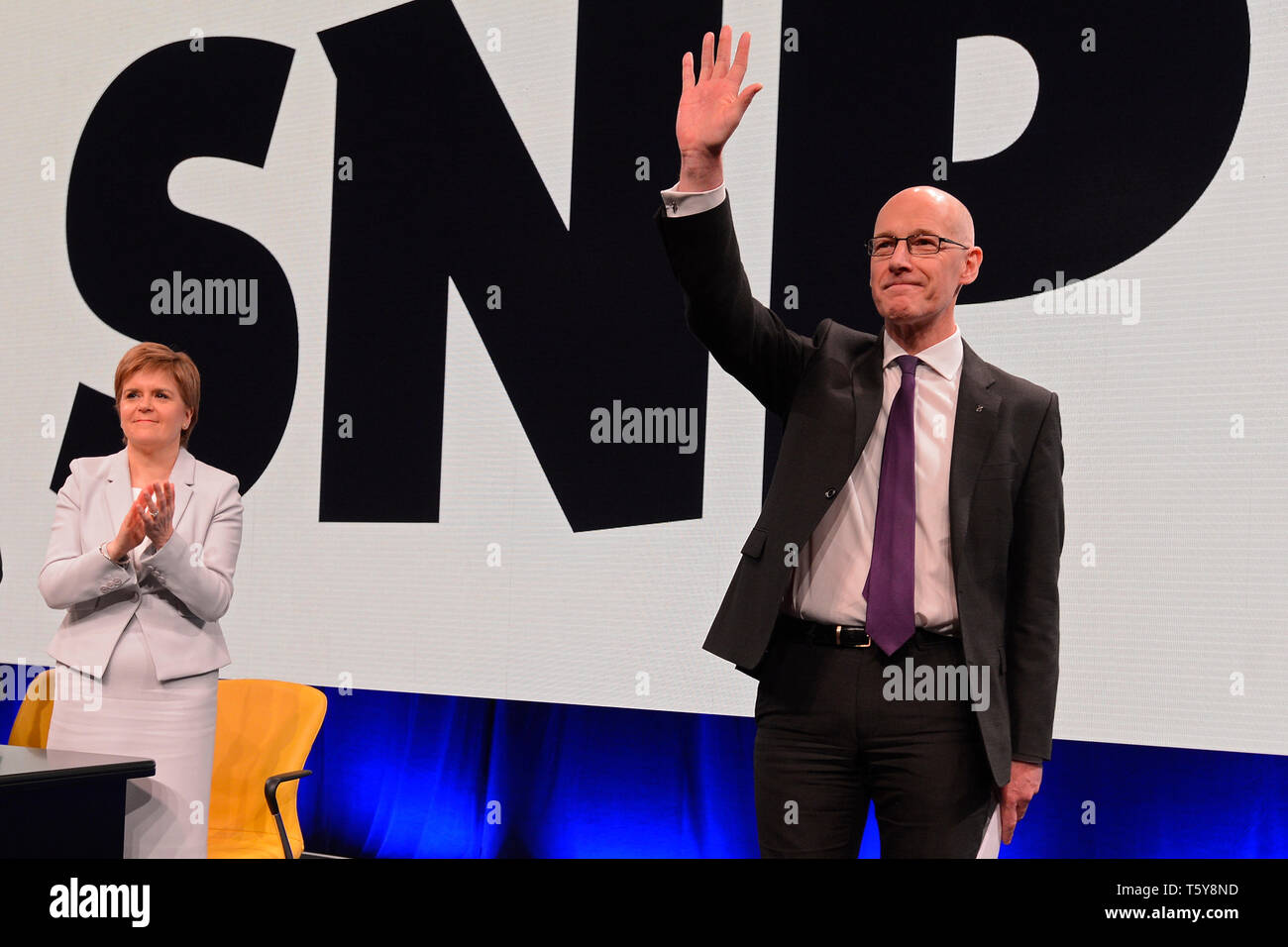 Edinburgh, Scotland, United Kingdom, 27, April, 2019. First Minister Nicola Sturgeon applauds Scottish Education Secretary and Deputy First Minister John Swinney after his speech to the Scottish National Party's Spring Conference in the Edinburgh International Conference Centre. © Ken Jack / Alamy Live News Stock Photo