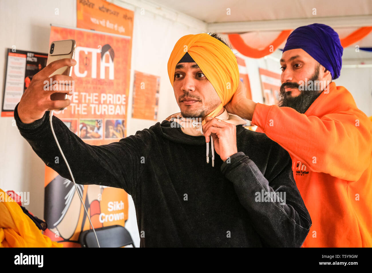 Trafalgar Square, London, UK, 27th April 2019. A turban tying demonstration. Vaisakhi Festival, a celebration of Sikh culture and heritage is once again brought back to Trafalgar Square. Highlights include colourful stage performances of kirtan and dharmic music, as well as food and cooking demonstrations. Credit: Imageplotter/Alamy Live News Stock Photo