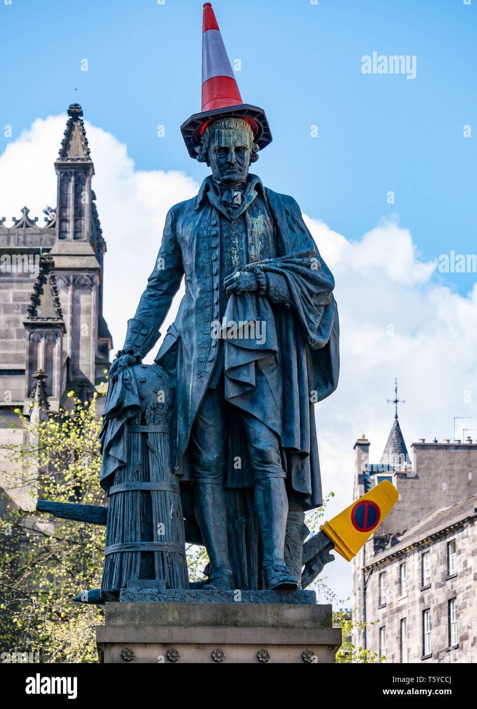 Royal Mile, Edinburgh, Scotland, United Kingdom, 27th April 2019.  Revellers decorate the Adam Smith statue with traffic cones in the Spring sunshine as he looks down on the tourists passing by Stock Photo