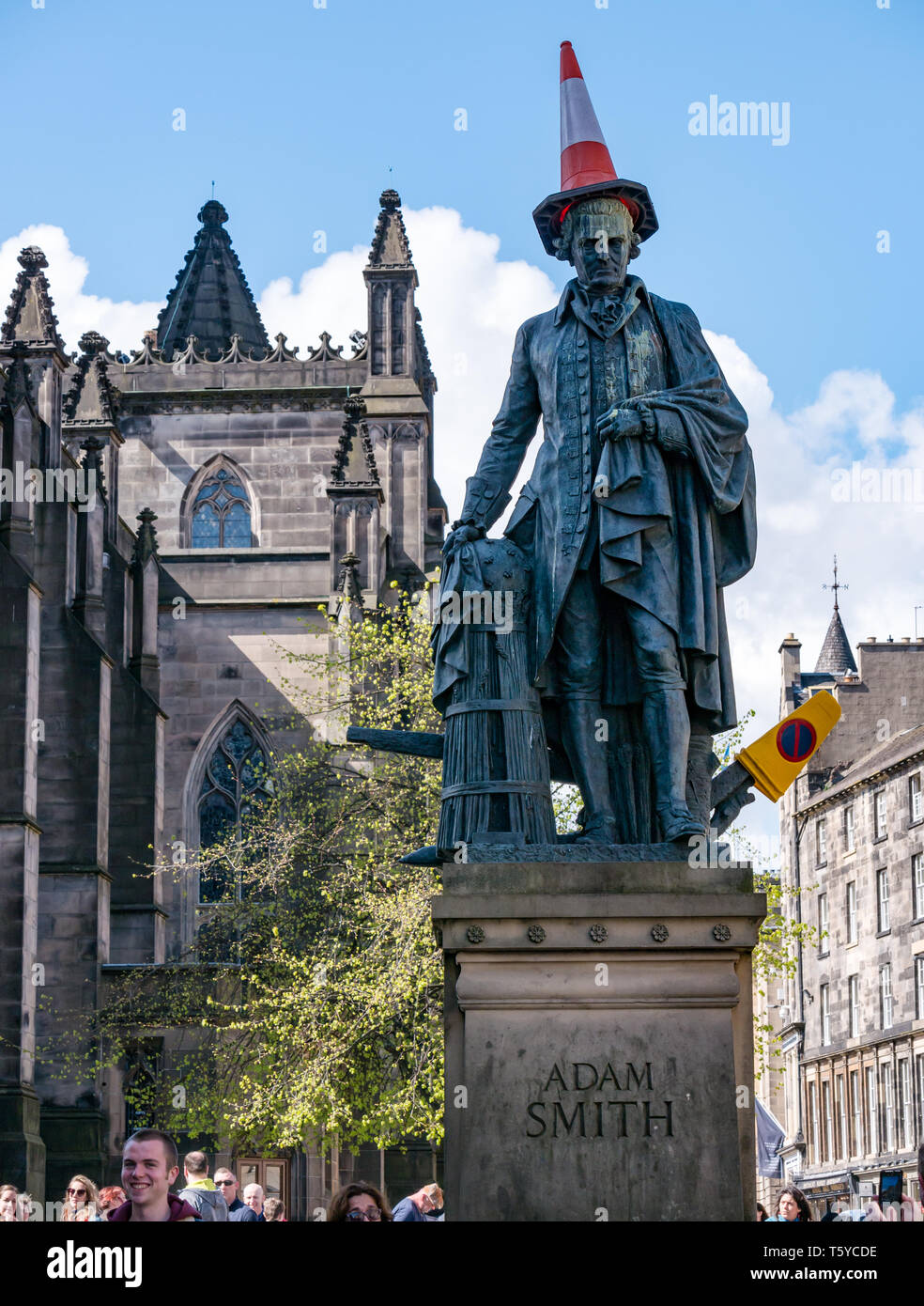 Royal Mile, Edinburgh, Scotland, United Kingdom, 27th April 2019.  Revellers decorate the Adam Smith statue with traffic cones in the Spring sunshine as he looks down on the tourists passing by Stock Photo