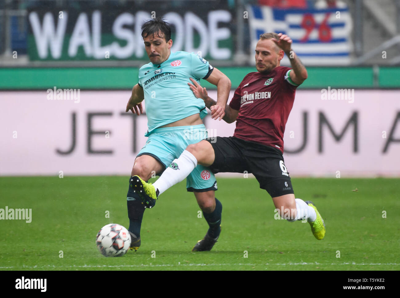 Hanover, Germany. 27th Apr, 2019. Mainz's Giulio Donati (L) vies with Hanover 96's Marvin Bakalorz during a German Bundesliga match between Hanover 96 and 1.FSV Mainz 05 in Hanover, Germany, on April 27, 2019. Hanover 96 won 1-0. Credit: Kevin Voigt/Xinhua/Alamy Live News Stock Photo