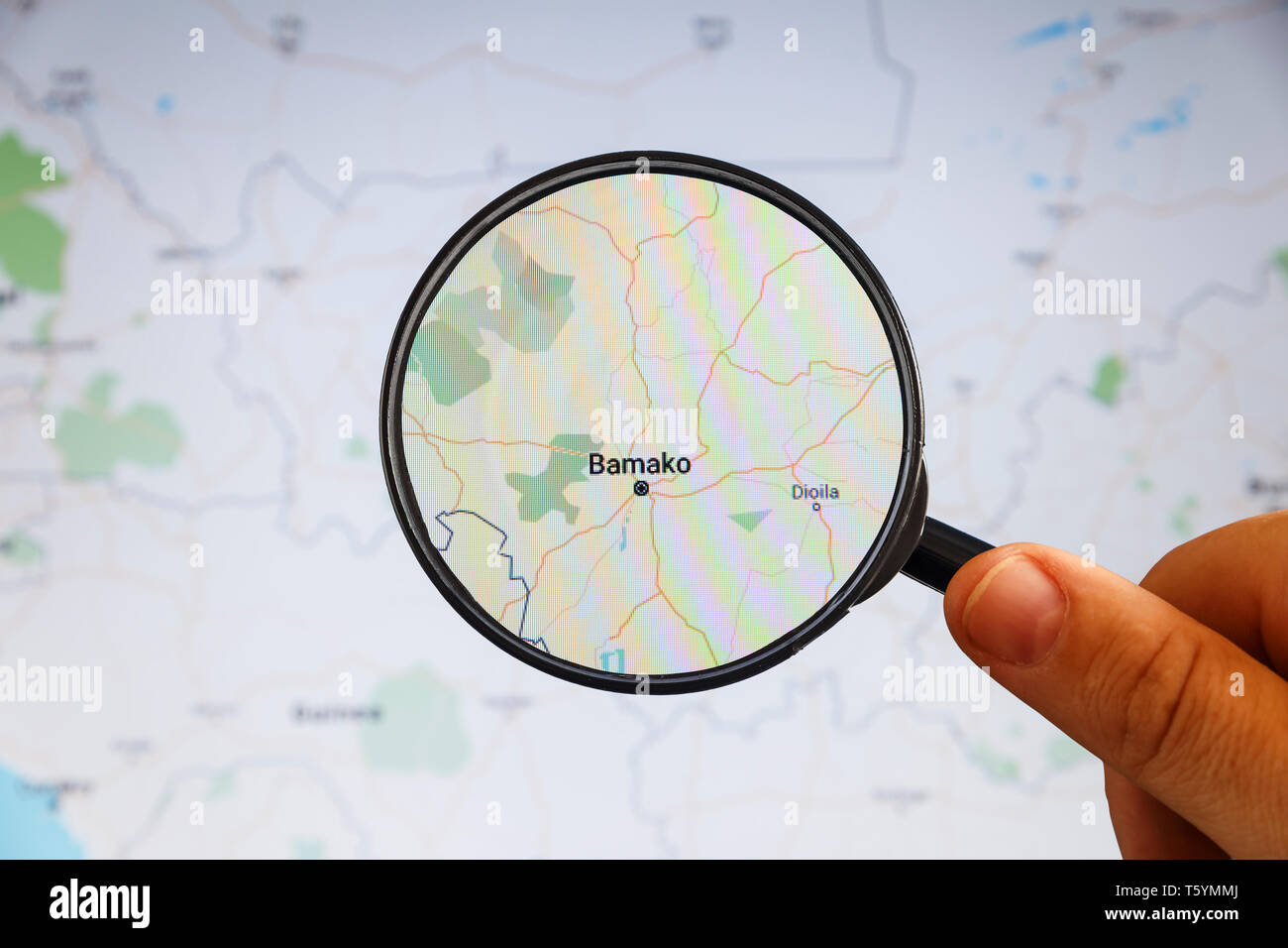 Bamako, Mali. Political map. City visualization illustrative concept on display screen through magnifying glass in the hand. Stock Photo