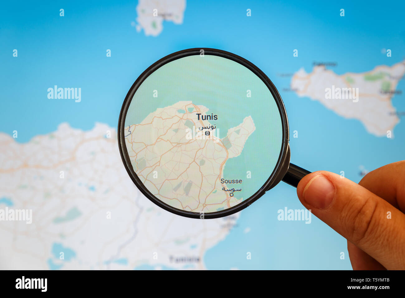 Tunis, Tunisia. Political map. City visualization illustrative concept on display screen through magnifying glass in the hand. Stock Photo