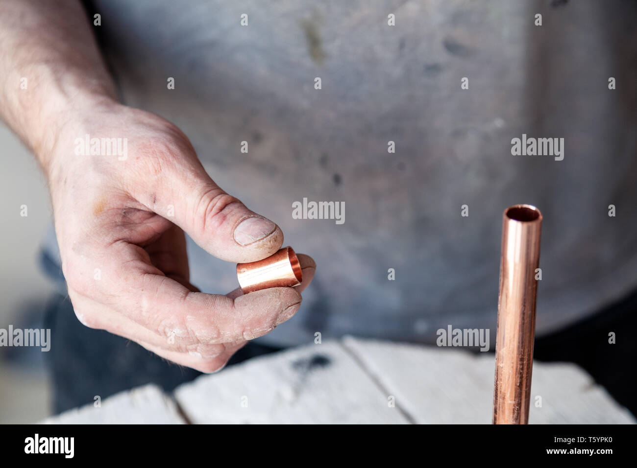 Closeup worker plumber master cleaning copper pipes with professional