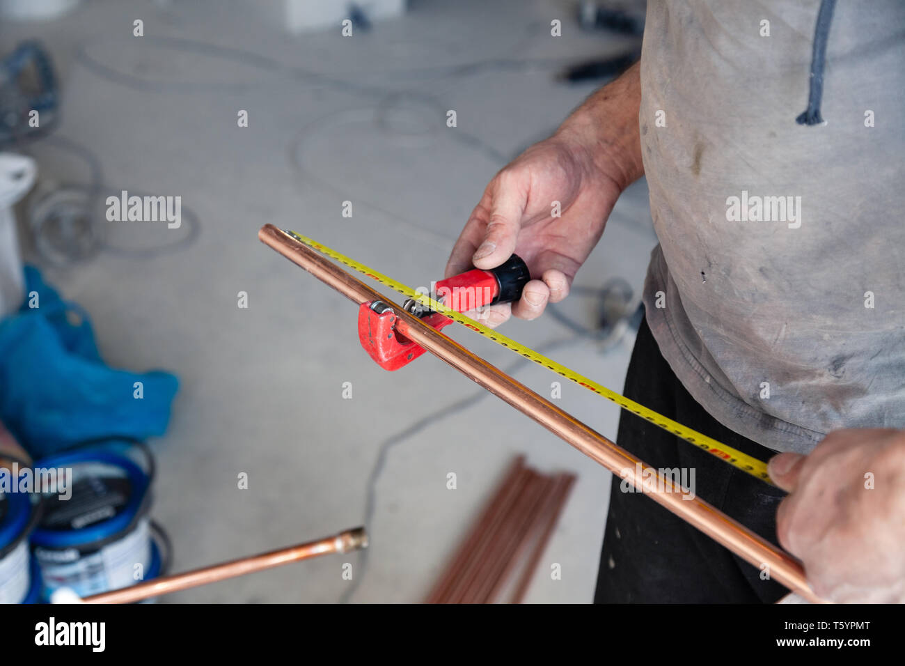 Closeup worker plumber master measures copper pipes with roulette tape