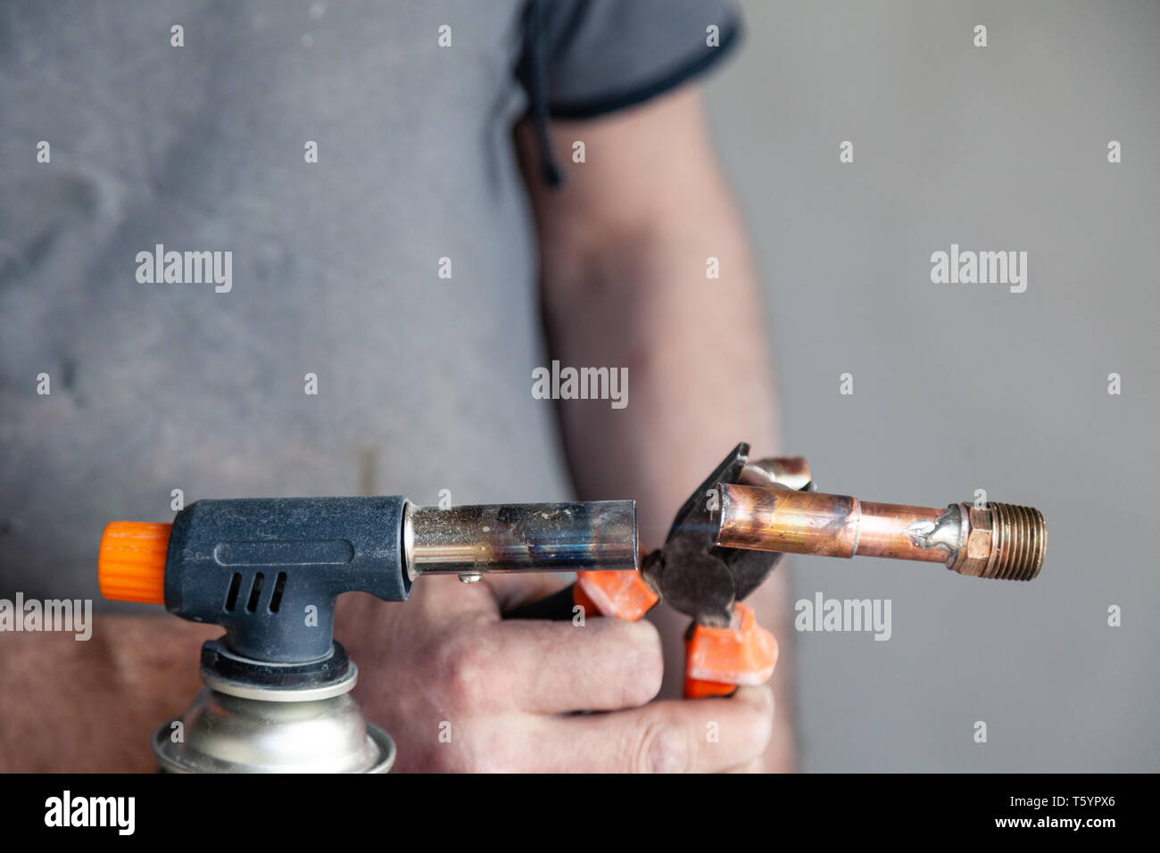 Closeup professional master plumber holding flux paste for soldering
