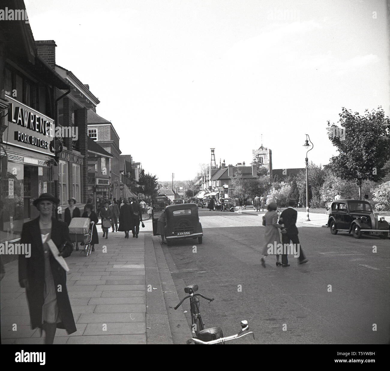 1940s, historical, a view from this era of Ruislip HIgh Street, West London, showing people and cars. The parish appears in the Domesday Book and remained a village for a long time until the expansion of the Metropolitan Railway from 1911 which saw the local population rise considerably. Stock Photo
